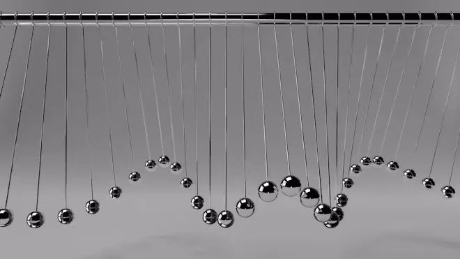 Rows of pendulums caught at different points in their swing, forming a wave